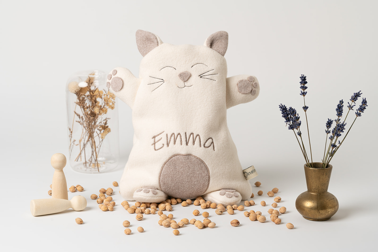 Wärmekissen Katze | personalisiert | verschiedene Farben 3 Wärmekissen Katze personalisiert in Farbe creme. Der Name des Kindes (in diesem Fall "Emma") wurde mit braunem Stickgarn in 4 cm großen Buchstaben in den Bauch eingestickt. Die Katze hat abstehende Ohren, Pfoten und einen Schweif. Abbildung der Vorderseite. Überzug sowie das Innenkissen sind pflegeleicht waschbar.