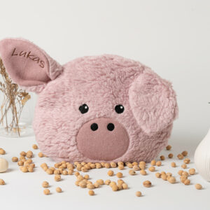 Wärmekissen Schweinchen in Farbe rosa. Zu sehen ist die Vorderseite, das Gesicht des Schweines, mit dunklen Augen und einem dunkelrosa Rüssel. Die Größe beträgt 23 cm * 20 cm. Der Überzug ist aus Biobaumwollplüsch und Biobaumwollvlies genäht. Zu sehen sind zwei schwarze, aufgenähte Augen, ein aufgenähter dunkelrosa Rüssel mit abstehenden und hängenden Ohren.