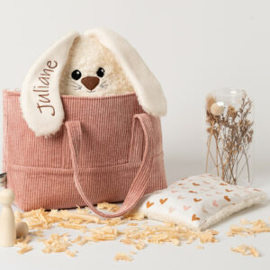 Geschenkset für Kinder -personalisiert-handgefertigt-waschbar-Steirerkissen. Das Set besteht aus einer Baumwolltasche mit Henkeln, ein Zirbenkissen Hase in Farbe Creme mit Zirbenfüllung und ein Kirschkernkissen passend zur Tasche. Der Hase ist hergestellt aus Baumwoll-Plüschstoff kombiniert Baumwoll-Vlies mit abstehenden Ohren in sitzender Position. Die Kulleraugen, die Schnauze, Barthaare sowie die Hinterpfoten sind aus Vliesstoff aufgenäht. Die Vorderpfoten stehen seitlich ab.